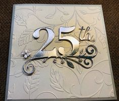 a 25th birthday card with the number twenty five in silver and flowers on white paper