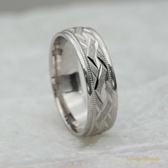 a wedding ring is shown on a white surface with an intricate design in the center