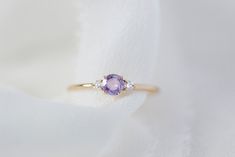 *This listing is for one Freya, purple sapphire + natural white diamonds only* She's finally here! Meet our newest addition to the family - Freya! Made of a natural alluring purple sapphire as a focal stone and accented with 2 sparkling with diamonds flanked on the side in solid 14K yellow gold on our signature fine and delicate band. Specifications: - Solid 14K Yellow Gold (no plating) - 1.2mm (width of band) - 0.25 CT natural purple sapphire, heated, VS clarity - 0.06 CWT natural white diamond Purple Sapphire Ring, Sapphire Wedding Band, Sparkly Ring, Purple Diamond, White Diamond Ring, Purple Sapphire, Purple Band, 925 Silver Jewelry, Blue Rings