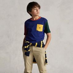 Polo Ralph Lauren T-Shirt In Blue, With A Yellow Pocket. The Left Sleeve Is Burgundy Red And The Right Sleeve Is Dark Green. In The Neck Opening There Is An Orange Edge. Blue Short Sleeve Tops With Contrast Color, Multicolor Crew Neck Tops For School, Casual Multicolor T-shirt For School, Casual Navy Color Block Tops, Playful Blue T-shirt For School, Multicolor Cotton Color Block Tops, Sporty Blue Patchwork Tops, Playful Color Block Cotton Tops, Playful Cotton Patchwork Tops