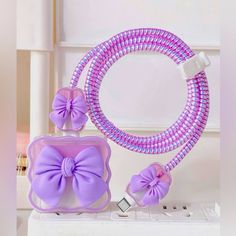 a purple and white purse sitting on top of a charger next to a round mirror