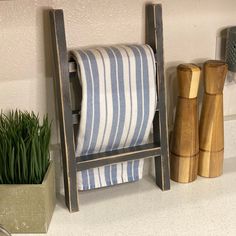 a towel rack with two bamboo sticks next to it and a potted plant in the corner