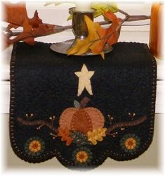 a black purse with a white star on the top and some leaves hanging from it