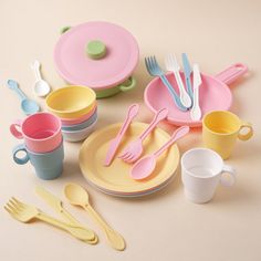 a collection of children's plastic dishes and utensils on a beige background