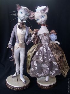 two cats dressed in fancy clothes standing next to each other