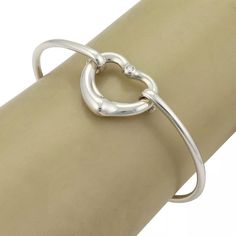 Material: sterling silver Hallmark: Tiffany & Co. Peretti 925 Spain Measurement: inner circumference: 6.5" x 0.10" thick Heart: 0.77" tall x 0.84" wide x 0.16" thick Weight: 13.4 grams  This authentic bangle is from Tiffany & Co. by designer Elsa Peretti from her Open Heart collection. It is crafted from sterling silver with a 2.5mm thick wire bangle, the front has the contour open heart with a 2 points diamond at the top of the heart. One end of the bangle has a small curved hook which and secu Luxury Sterling Silver Bracelets For Valentine's Day, Sterling Silver Clasp Bracelet For Valentine's Day Anniversary, Anniversary Bracelet With Sterling Silver Clasp For Valentine's Day, Valentine's Day Sterling Silver Bracelets With Silver Clasp, Valentine's Day Anniversary Bracelet With Sterling Silver Clasp, Valentine's Day Sterling Silver Bracelets, Luxury Sterling Silver Heart Bracelet For Anniversary, Heart-shaped Sterling Silver Bracelet With Silver Clasp, Heart-shaped Sterling Silver Bracelets With Clasp