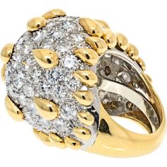 Bask in the glow of luxury, where timeless elegance meets modern aesthetics in the David Webb Platinum & 18K Yellow Gold Bombe Diamond Cluster Gold Tear Drop Details Ring. This exquisite ring, designed by David Webb, is a true masterpiece that captures the essence of opulence and sophistication. Crafted in a blend of platinum and 18k yellow gold, this ring exudes a classic yet contemporary charm, making it a versatile and coveted piece in any fine jewelry collection.At the heart of this stunning ring is a diamond dome surface that radiates with brilliance, showcasing approximately 10.00 carats of dazzling diamonds. The dome design creates a captivating visual effect, catching and reflecting light from every angle, while the high-polished yellow gold tear drop details add a touch of glamour Luxury Diamond Dome Ring With Accents, Luxury Gold Diamond Dome Ring, Luxury Domed Collectible Ring, Luxury Hallmarked Collectible Dome Ring, David Webb Ring, Designer Diamond Jewellery, David Webb, Yellow Jewelry, Diamond Birthstone