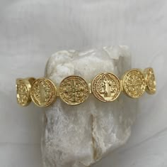 Gorgeously unique, this stunning medal coin cuff bracelet is perfect for wearing alone or stack with some of our gold fill bead bracelets. The Benedictine Medal is one of the most powerful symbols of divine protection. Wear this petite bracelet as a reminder that you are protected by God's army and as St Benedict did, to do good every day.  Tradition holds that it stands for the power of prayer in times of temptation and suffering, wards against evil, and symbolizes how prayer creates peace within ourselves and in our communities. Specifications - Adjustable cuff, one size fits most, up to wrist size 7.5 18kt gold plated or sterling silver plated Cheap Symbolic Bracelets, Luxury Gold Medallion Bracelets, Cheap Gold Spiritual Bracelets, Spiritual Jewelry Gold, Vintage Gold Plated Bracelets, Gold Antique Bracelet, God's Army, Czech Beads Jewelry, Keep Bracelet