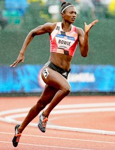 a woman running on a track in the rain