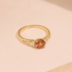 Crafted in 14k Solid Gold, our Braided Padparadscha Engagement Ring is a vintage-inspired masterpiece. The captivating Oranged-hued gemstone, intricately braided band, and delicate accents create a unique and elegant piece. Whether for an engagement or an anniversary, this ring symbolizes enduring love and timeless beauty. Make her heart skip a beat with this exquisite ring that's as extraordinary as she is. Ring Details * Gold Kt: 10k 14k 18k Solid Gold * Band Options; Yellow Gold, White Gold, Rose Gold * Band Width: 1.60 mm * Top Width: 6.00 mm * Thickness: 1.40 mm * Gemstone: Lab Created Padparadscha - Round 6mm * Gemstone: Diamond * Gem Color and Clarity: G Colour SI Clarity * Diamond CTW: 0.12ctw  🦄 Find out more about my shop at: https://etsy.me/3uTPmyQ 💅 Go Directly to My Sections Gold Round Engagement Ring, Padparadscha Sapphire Ring, Pink Gemstone Ring, Pink Gemstones Ring, Round Engagement Ring, Ring Crystal, Padparadscha Sapphire, Solid Gold Band, Round Engagement Rings