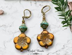 Elevate your boho chic style with these stunning dangle earrings featuring vibrant orange Czech glass flower beads paired with eye-catching turquoise Picasso glass bicone beads. The unique combination of colors and textures adds a playful touch to any outfit. You can choose your preferred earwires to suit your personal style. These earrings are the perfect accessory to make a statement with a pop of color and bohemian charm. These earrings are sure to be a favorite in your jewelry collection! 𝐋 Bohemian Czech Glass Dangle Flower Earrings, Bohemian Orange Czech Glass Earrings, Bohemian Czech Glass Flower Earrings, Bohemian Beaded Earrings With Flower Charm, Bohemian Flower Earrings With Czech Glass, Bohemian Flower Czech Glass Earrings, Bohemian Orange Flower Beaded Earrings, Bohemian Orange Flower Jewelry, Orange Bohemian Flower-shaped Jewelry