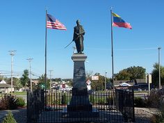 there is a statue in the middle of two flags