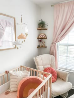 a baby's room with a crib, rocking chair and pink drapes