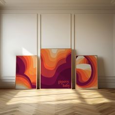 three abstract paintings on the wall in an empty room