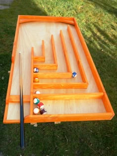 a pool table made out of wood with balls and cues in the bottom row, ready to be played