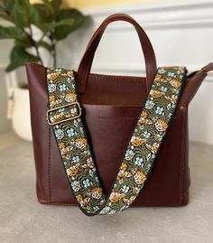 "Update and refresh your bags with this lovely floral embroidered purse strap in colors of green, blue, pink and black.  Straps can come in antique brass / bronze, gold or silver hardware to perfectly match your bag and style.  Strap is 2\" wide and has an adjustable length from 30.5\"-55\" (including hardware) ~contact me if you would like a custom length~ These replacement guitar straps for handbags are made with high-quality durable metal buckles and premium woven material Whether you are heading to a music festival, a night out on the town, or just running errands, this embroidered guitar style crossbody purse strap is the perfect addition to your accessory collection. It is not only fashionable but also functional and versatile, making it an ideal choice for any occasion." Embroidered Guitar, Retro Guitar, Crossbody Bag Strap, Embroidered Purse, Guitar Straps, Floral Purse, Bronze Gold, Purse Strap, Guitar Strap