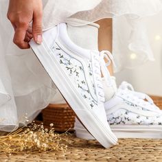 a person in white sneakers is tying their shoes