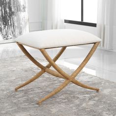 a white cushion sitting on top of a wooden bench in front of a curtained window