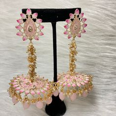 The exquisite and unique Baby Pink Nashira Jhumka are the perfect jhumkas for both party wear. This beautiful drop jhumka features dangling pearls, Baby Pink beads, Hand-painted Meenakari, and high-quality kundan on Gold-Plating. Specifications Materials used: Baby Pink Beads, Meenakari, pearls, gold plating Length: 10 cm Weight: 38 grams At Romikas, we pride ourselves on the craftsmanship and high quality of our jewelry, designed to enhance your natural beauty. Please contact us with any questi Festive Bridal Earrings With Meenakari, Temple Jewelry Style Jhumkas With Latkans For Party, Navratri Festive Meenakari Danglers, Traditional Peacock Design Danglers For Party, Traditional Peacock Danglers For Party, Party Chandbali Danglers With Peacock Design, Party Peacock Chandbali Danglers, Party Peacock Design Chandbali Danglers, Temple Jewelry Jhumkas For Party