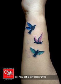 a wrist tattoo with three birds flying in the sky and on it's side