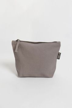 If you’ve been looking for an eco-friendly makeup bag to tame and organize cosmetic items, consider the simple and affordable Lok Pouch. Made from sustainably grown organic cotton canvas, the Lok Pouch’s dimensions (7" X 9" x 3" ) are large enough to accommodate most cosmetic containers and accessories but small enough to easily toss into a larger tote or pack. It has a 7-inch zippered opening with a long pull and a gusseted bottom panel, so it stands up on the countertop for easy access. Conten Eco Friendly Makeup, Cosmetic Containers, Cosmetic Items, Large Tote, Zipper Pouch, Makeup Bag, Light Grey, Urban Outfitters, Organic Cotton