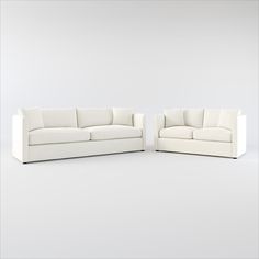 two white couches sitting next to each other on top of a white flooring