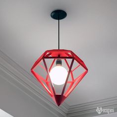 a red light fixture hanging from the ceiling in a room with white walls and ceilings