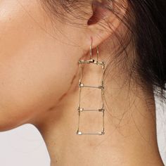 We aren't sure what makes these earrings so smashingly perfect, is it their simple geometry or their geometric simplicity? Either way, their modern architectural look and nearly weightless comfort will make these your go-to accessory for both casual and elegant occasions. Made of durable fine steel cable segments adorned with gold-filled accents. Wires are hypoallergenic stainless steel. Length 3". Made in USA. Designer details → Minimalist Metal Wrap Earrings, Modern Metal Wrap Earrings, Modern Linear Earrings For Everyday Wear, Modern Yellow Gold Linear Earrings, Modern Brass Wrap Earrings, Modern Yellow Gold Wrap Earrings, Geometric Metal Earrings For Everyday, Modern Everyday Linear Earrings With Ear Wire, Modern Linear Earrings For Everyday