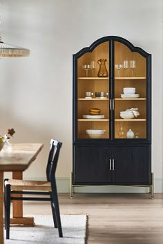 a black china cabinet with glass doors in a dining room