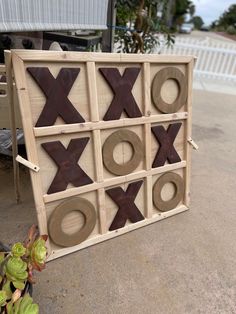 a wooden tic - tac - toe board with various shapes and sizes on it