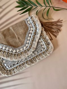 Natural brown jute  boho bag with beading and coin work and trim of tassels and braided leather sling Bohemian Tassel Clutch Bag, Bohemian Clutch Bag With Tassels, Beaded Beige Bags For Festivals, Bohemian Beaded Clutch For Festivals, Festival Beaded Beige Bags, Bohemian Beaded Natural Color Bag, Beige Beaded Festival Bags, Bohemian Embellished Clutch As Gift, Bohemian Embellished Clutch Gift