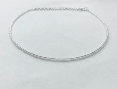 This dainty clear beaded necklace is made with glass seed beads.  It is a perfect necklace for layering or to wear on its own! The necklace is approximately 14 inches long with 3 inches of extender chain, making it easily adjustable.  Looking for a simple necklace that goes with every outfit? Look no further! This beautiful clear necklace makes a great gift or purchase for yourself! Transparent Beads Necklace, Minimalist Faceted Beads Choker For Gift, Delicate Adjustable Beaded Necklace With Faceted Beads, Dainty Adjustable Choker With Faceted Beads, Elegant Tiny Beads Crystal Choker Necklace, Silver Crystal Necklace With Tiny Beads As A Gift, Elegant Crystal Choker Necklace With Tiny Beads, Silver Minimalist Beaded Necklace With Delicate Chain, Dainty Crystal Necklaces With Tiny Beads