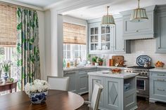 a kitchen with blue cabinets and white counter tops, an island in front of the stove