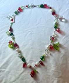 handmade, one of a kind beaded necklace. green and red strawberry flower charms and beads. silver finishings, including a lobster clasp closer. perfect for the spring or a gift!  thank you so much for your support! please don't hesitate to ask me any questions:) Fruit Beaded Necklace, Red Beaded Whimsical Jewelry, Whimsical Red Beaded Jewelry, Whimsical Green Beaded Necklaces As Gift, Whimsical Green Beaded Necklaces For Gift, Strawberry Flower, Fairy Necklace, Red Strawberry, Diy Hair Bows