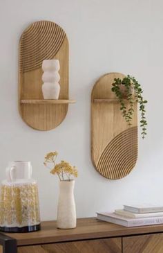 two wooden wall shelves with vases and plants on them in front of a white wall