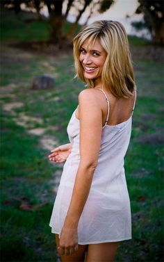 a woman in a white dress posing for the camera