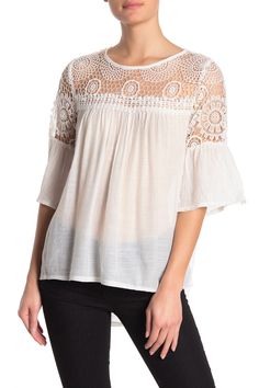 Three-quarter sleeves and crochet lace knit detailing accentuates this dainty blouse. Crew neck. 3/4 length sleeves. Crochet lace knit detail. Contrast details. Solid. Approx. 30" length (size M). Imported Feminine Crochet Top With Lace Trim, Spring Crochet Top With Lace Trim For Brunch, Feminine Lace Trim Crochet Top, Feminine Lace Top With Pointelle Knit, Lace Blouse With Crochet Trim For Brunch, White Crochet Top With Lace Sleeves For Spring, Spring Lace Blouse With 3/4 Sleeves, Elegant Lace Blouse With Crochet Trim, Lace Blouse With 3/4 Sleeves For Spring