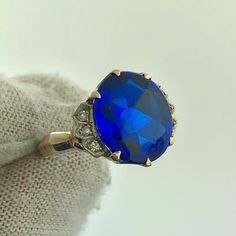 * Retro 14K Yellow Gold Oval Blue Spinel Diamond Accented Statement Cocktail Ring * Ring size: 5.80 * Top of ring measures: 1/2" x 5/8" * Height: 1/8" * Blue Spinel oval measures: approximately 12.0 mm x 10.0 mm * Diamonds measure: approximately 1.0 mm each * Ring weight: 3.1 tgw * Marked: 14K * 6 9 * Condition: Good. Unusual. Slight abrasions on stone  * G1751    Exported By ExportYourStore :) Blue Gemstone Cluster Ring For Formal Occasions, Blue Diamond Ring With 17 Jewels For Anniversary, 14k Gold Blue Sapphire Ring With 17 Jewels, Heirloom Blue Sapphire Ring With Center Stone, Blue Gemstone Cluster Ring Vintage Style, Blue Oval Topaz Ring For Anniversary, Antique Blue Cluster Ring For Wedding, Blue Topaz Ring Stamped 14k Gold, Oval Blue Diamond Ring