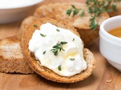 an open face sandwich with sour cream and herbs on top, next to a bowl of soup