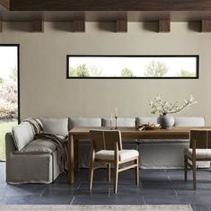 a living room filled with furniture and a wooden table in front of a large window