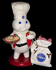 a statue of a chef holding a plate of food next to a bag of cookies