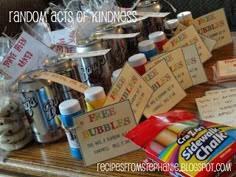 random acts of kindness are displayed on a table with candy and other items for sale