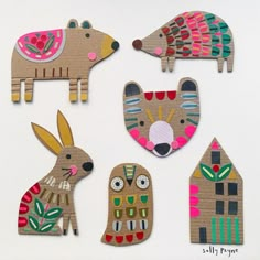 four wooden cut outs with animals and houses in the shape of rabbits, deers, and hedgehogs