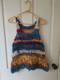 "Scrappy Vest This boho scrap vest/tank is light, airy, and great for warm weather. Layer over a cami, tank, or tee, or even a long-sleeved top.  Size S/M Measurements taken while garment laying flat.  Pit-to-pit: 17\" Bottom hem width: 22\" Length top of strap to hem: 21\" For reference, model is 5'2\", 140 lbs and typically wears size S to M.  Sustainability and environmental responsibility are important to me. For this reason, I primarily use use/incorporate leftovers from my existing yarn st Multicolor Vest Tank Top For Festival, Multicolor Camisole Tops For Beach, Bohemian Crochet Top For Summer Layering, Bohemian Camisole Tank Top For Summer, Multicolor Cami Tops For Beach, Bohemian Cami Top For Vacation, Cotton Cami Vest For The Beach, Cotton Cami Vest For Beach, Multicolor Vest-style Cami Tops