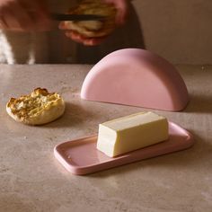 a person holding a piece of food next to a plate with a pastry on it