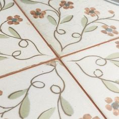 the tile is decorated with flowers and leaves