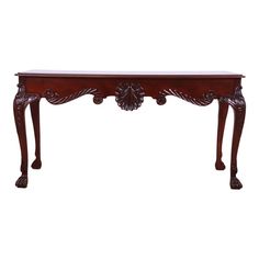 an ornate wooden table with carved legs and carvings on the top, against a white background