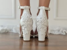 a woman's white high heeled wedding shoes