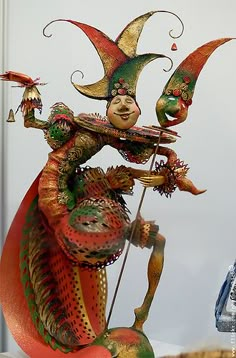 a statue of a clown holding a platter and standing on it's hind legs