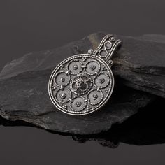 A faithful and carefully handmade replica of the Viking pendant found in Hälsingtuna in Sweden. It comes with beautiful filigree details. Extra work has been put into the fine details of this premium item, as well as into polishing and other finalizing work. Size: 36 x 26 mm Material: Sterling Silver 925 Diameter of hole: 3 mm Does not include a chain Artisan Oxidized Pendant Jewelry, Ornate Medallion Coin Pendant Jewelry, Ornate Medallion Jewelry With Coin Pendant, Engraved Round Pendant For Rituals, Artisan Jewelry With Coin Pendant, Traditional Engraved Flower Pendant Necklace, Spiritual Filigree Medallion Jewelry, Spiritual Ceremonial Filigree Jewelry, Spiritual Antique Silver Jewelry With Intricate Design